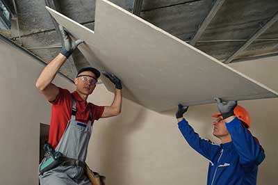 Two workers installing ceiling, NY Contractors Insurance